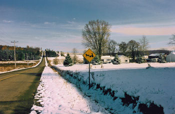 Snowy landscape with road sign warning for horse and carriage