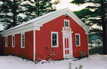 Small red building with white door and windows