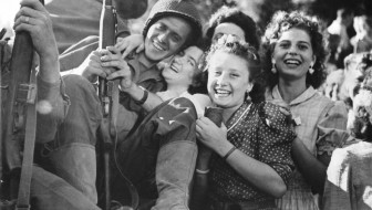 Allied soldier hugged by girls.