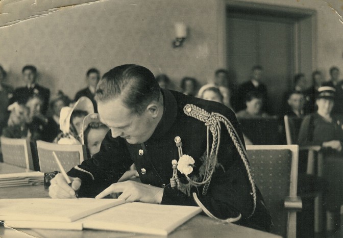 Man in uniform signing a document