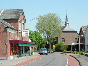 Street with a house on the left and a church on the right
