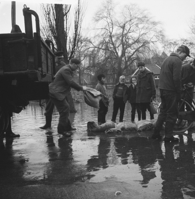 Protecting property by putting down sandbags.