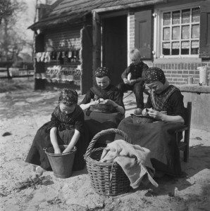 Children peeling potatoes while wearing traditional costumes, 1946