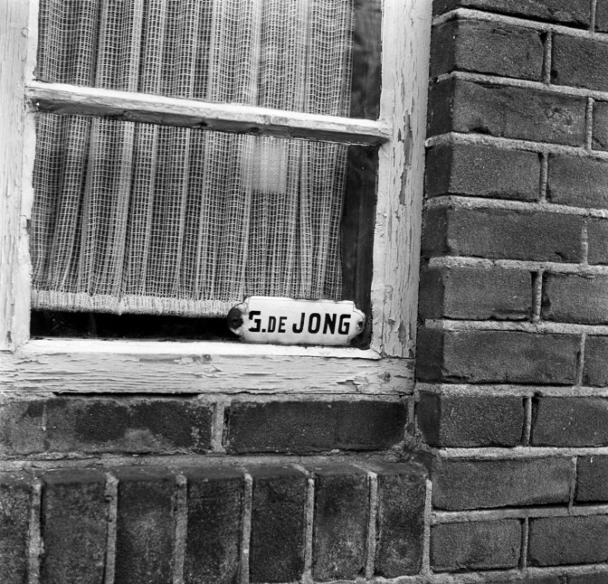 G de Jong name tag in a window