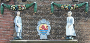 A statue of a man and a woman next to the crest of Zeeland