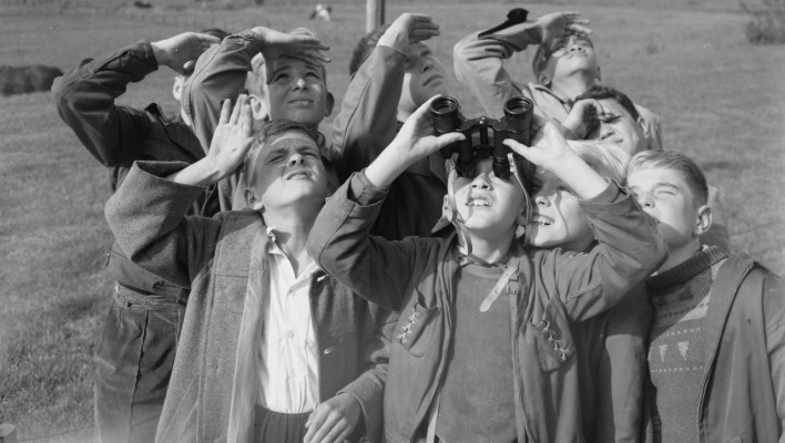 Boys looking up with binoculars
