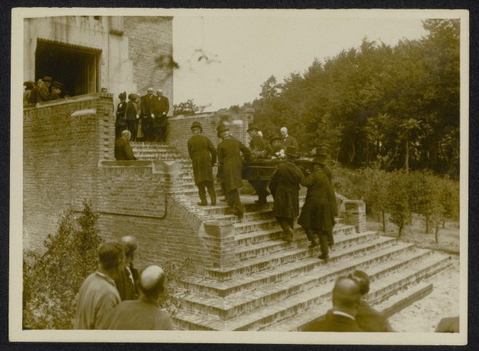 coffin carried up the stairs into the crematorium