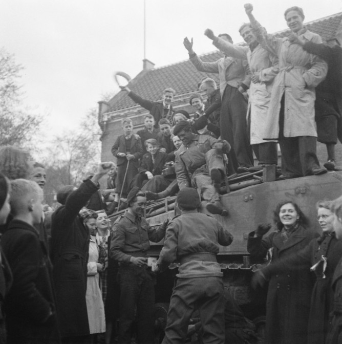 Dutch citizens climbing onto a British tank