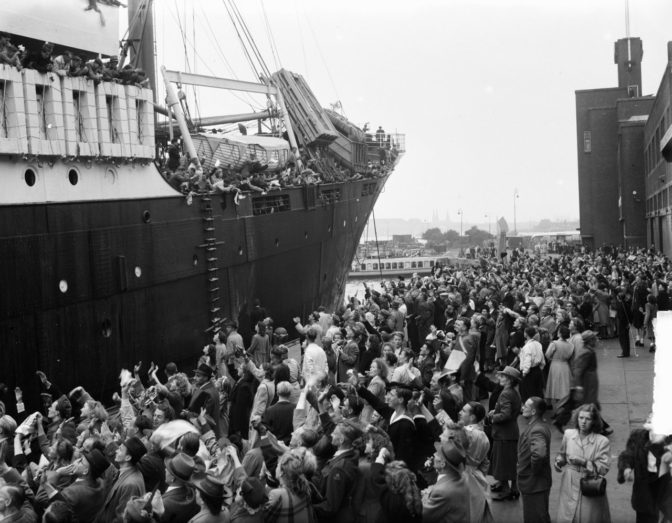 ship in port with passengers flocking to the side