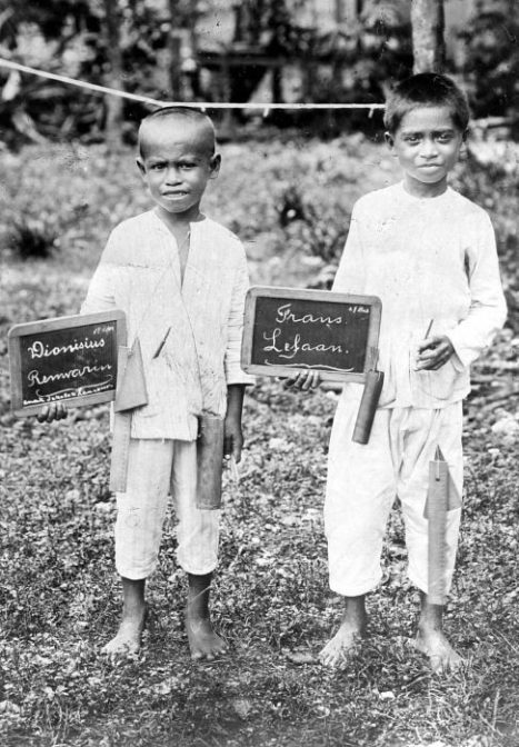 two boys showing blackboards with their names